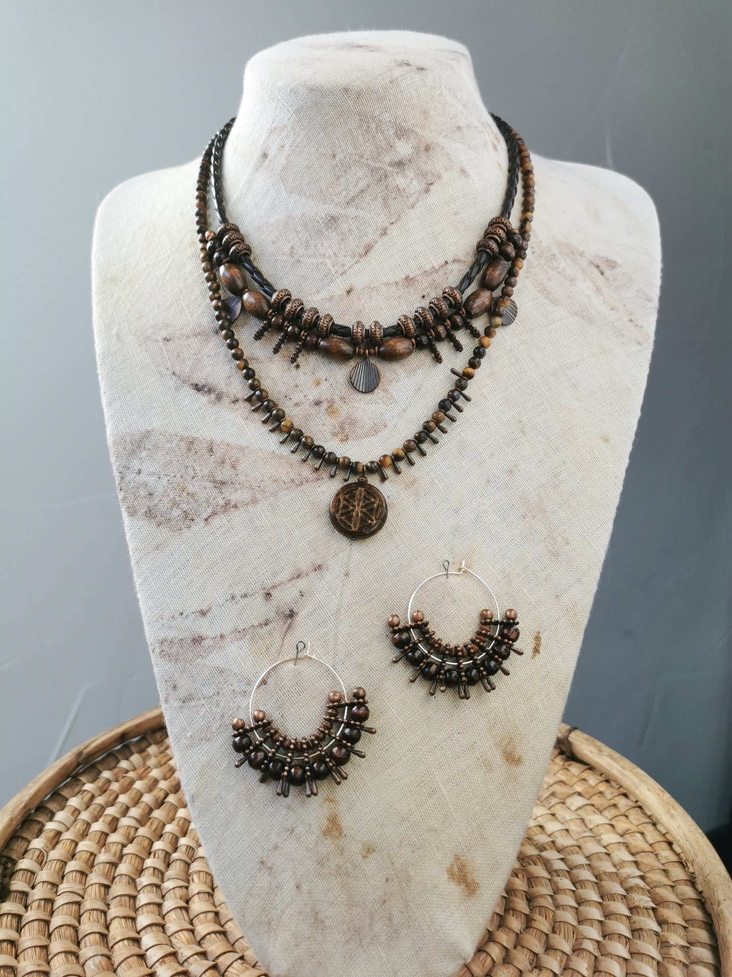 two boho necklaces and earrings set on a display