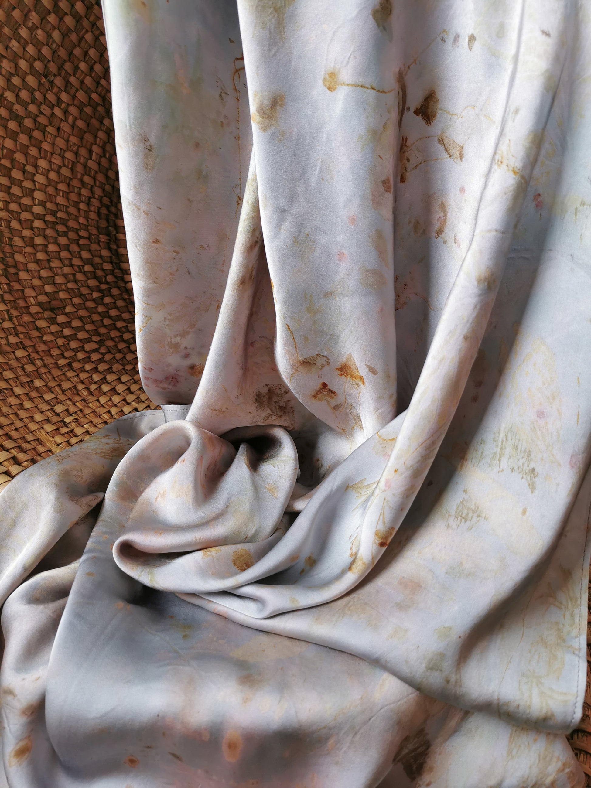 silver botanical dye silk shawl on a textured surface