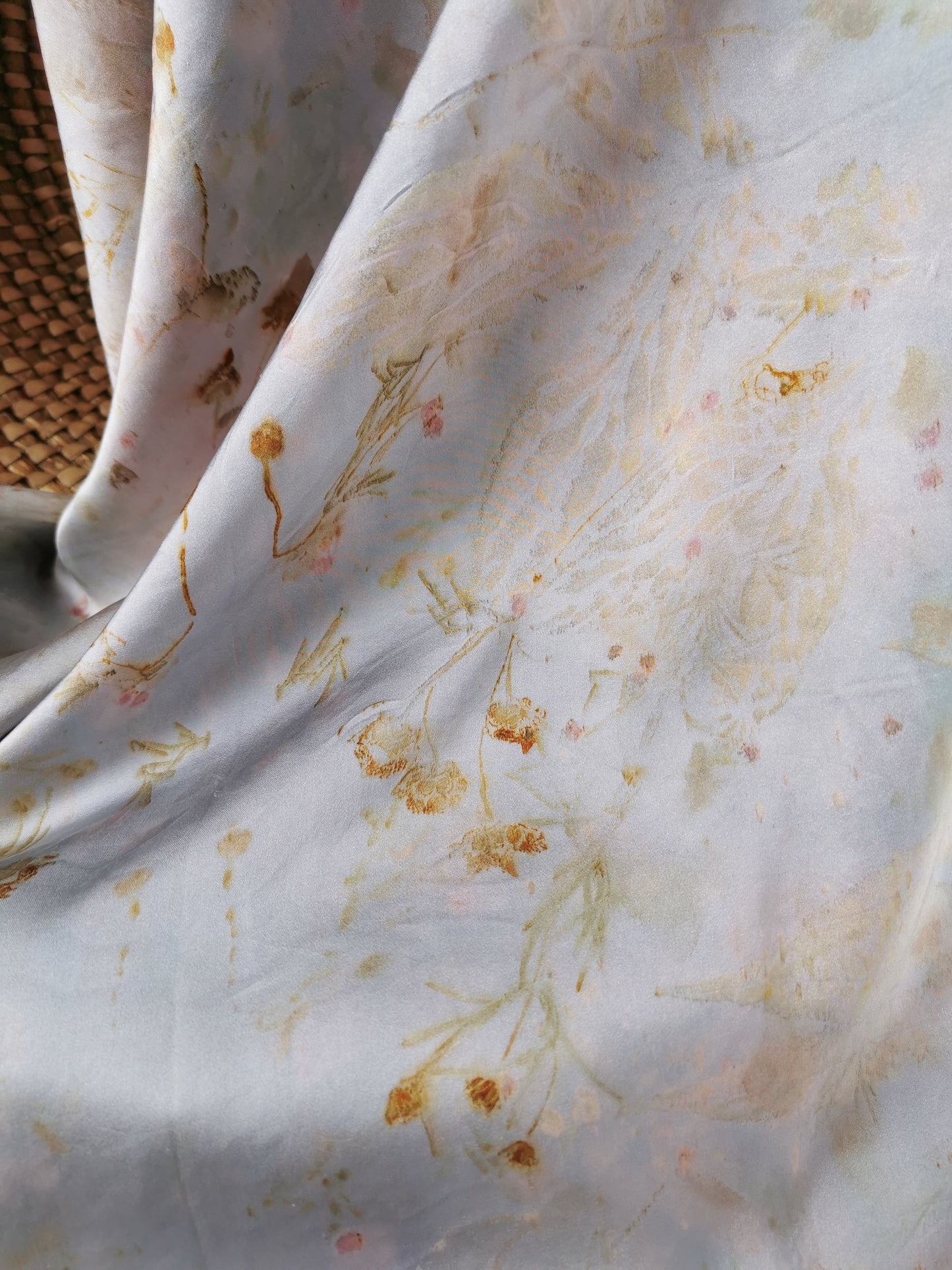 silver botanical dye silk shawl with a wicker basket in the background