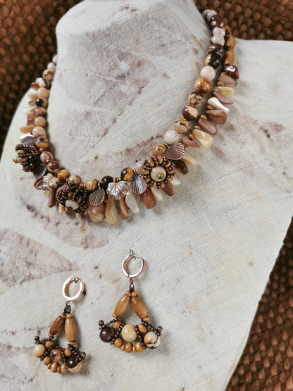 statement bead and charm necklace with earrings on a display