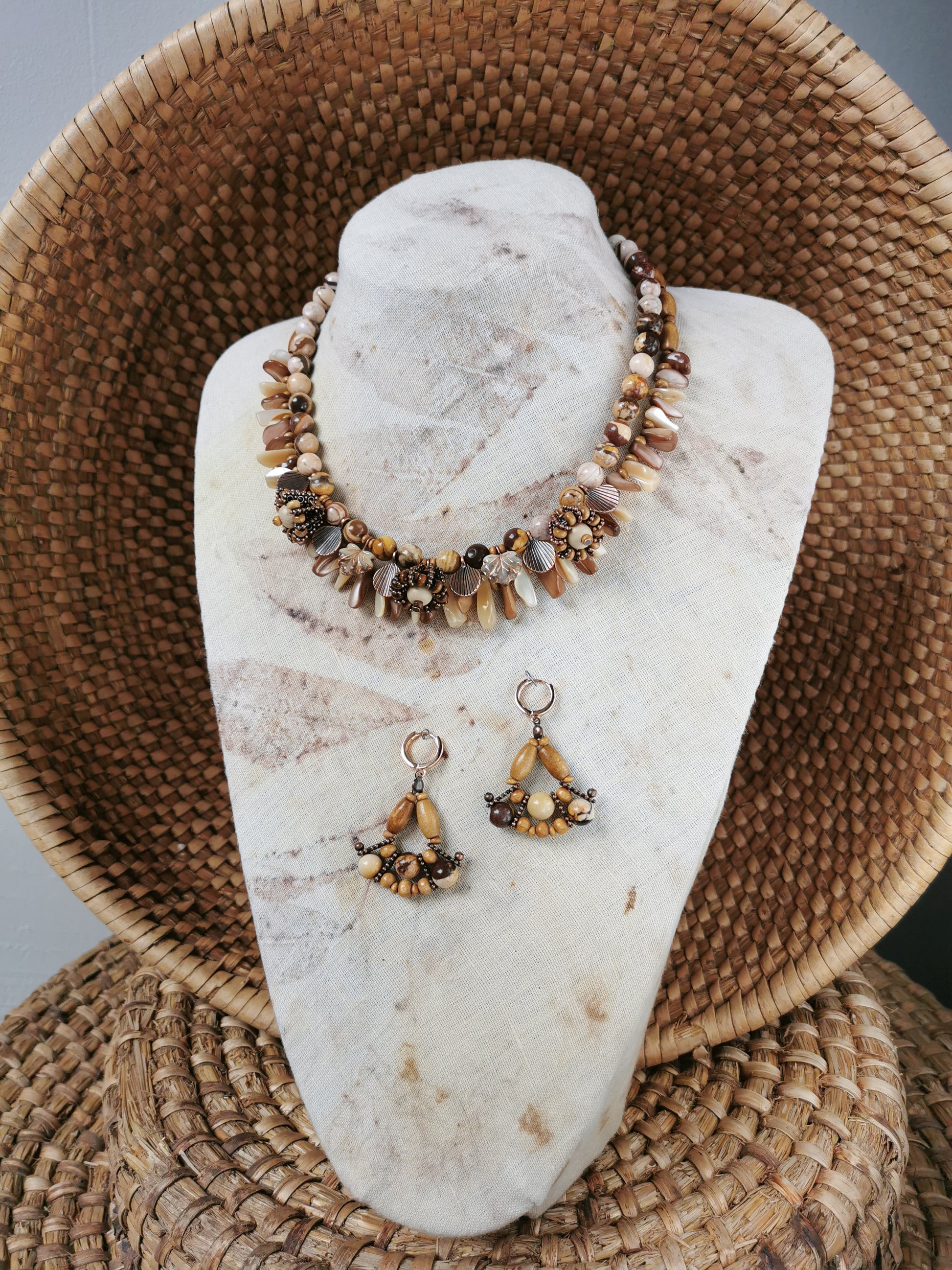 statement bead and charm necklace with earrings on a display