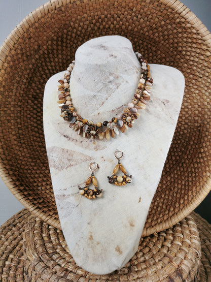 statement bead and charm necklace with earrings on a display