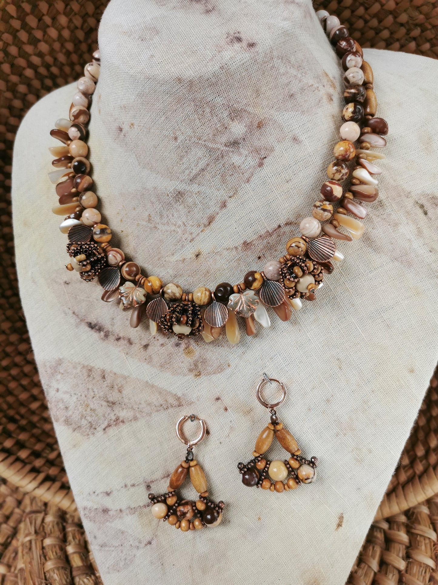 statement bead and charm necklace with earrings on a display
