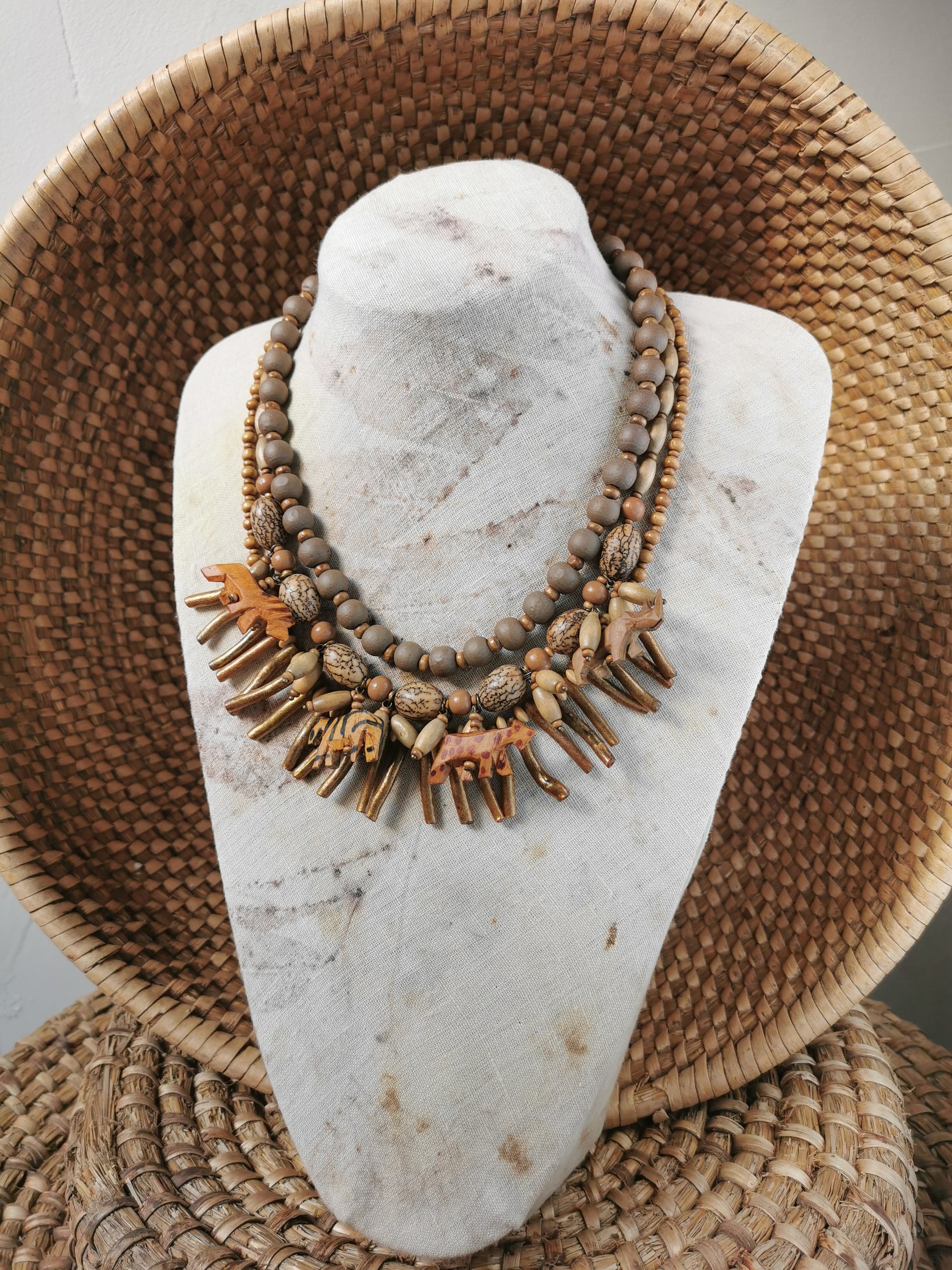 statement wild animal charm necklace with natural elements on a stone surface with woven background
