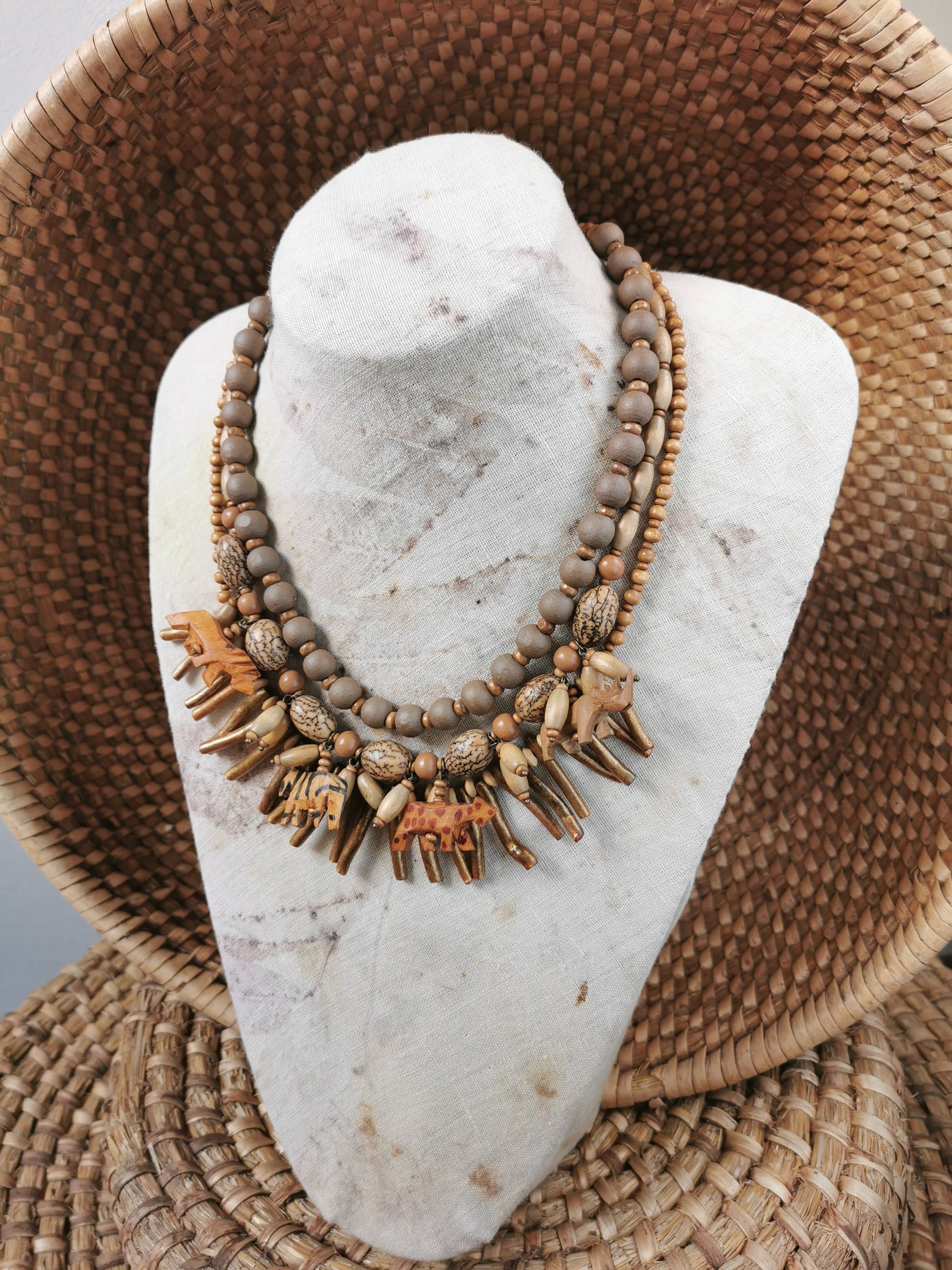 statement wild animal charm necklace with natural elements on a stone and woven surface