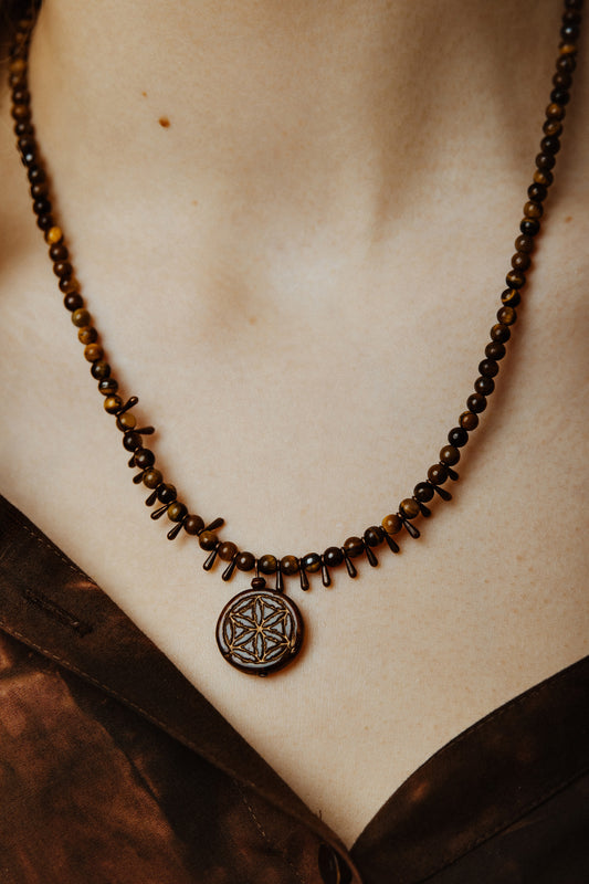 Necklace with a pendant on a person's neck, with a blurred background