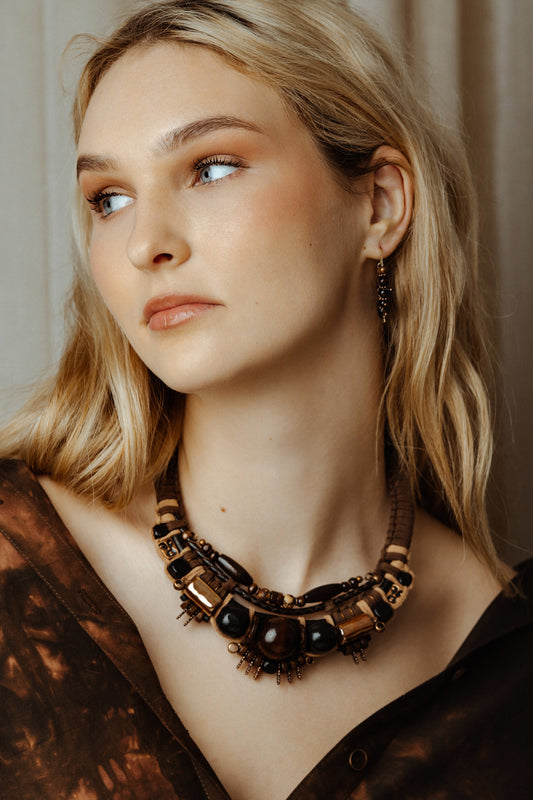 Woman wearing tribal gold face necklace necklace with a neutral background