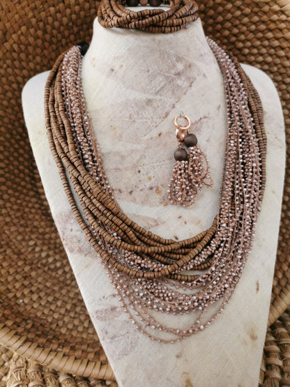 Necklace with multiple strands and a tassel bead earrings on a mannequin bust.
