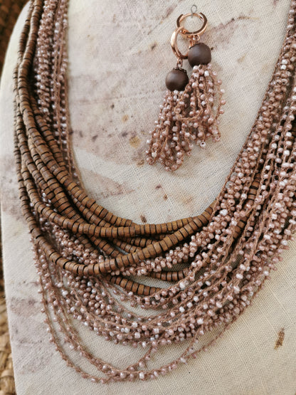 Necklace with multiple strands of beads and tassels on a textured surface