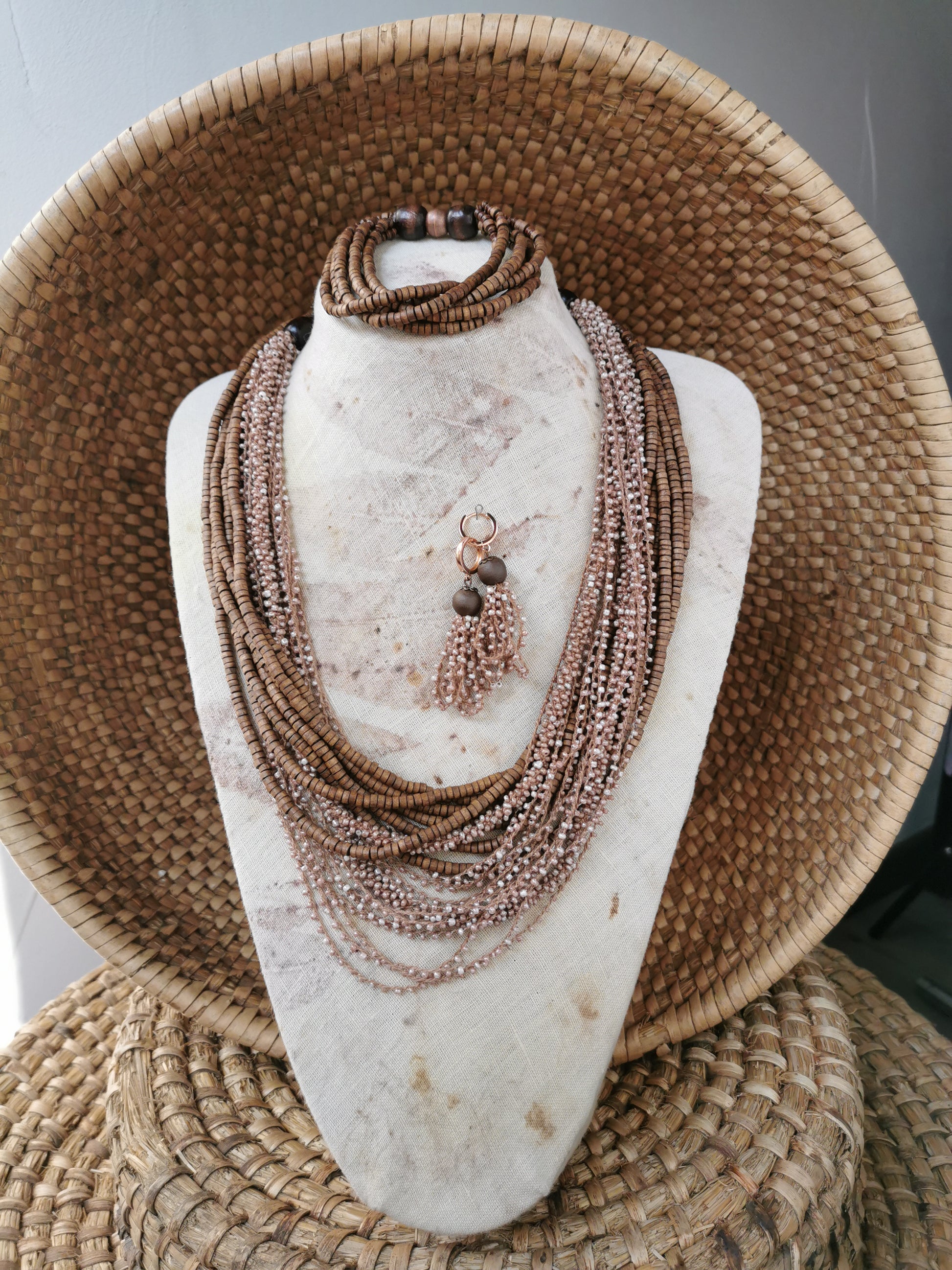 Necklace set on a mannequin bust with woven basket background