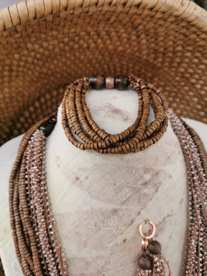Brown beaded necklace on a marble surface with woven background