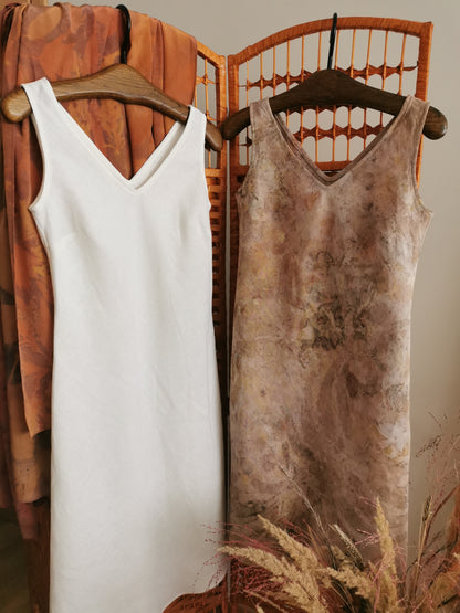 Two dresses hanging on a rack with a rustic background