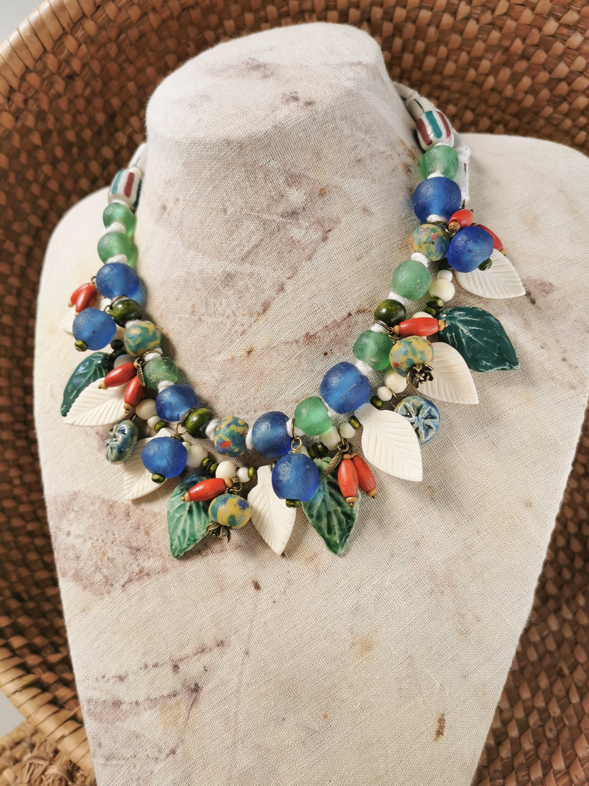 Colorful whimsical floral charm necklace  on a stone surface