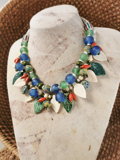 Colorful whimsical floral charm necklace  on a stone surface
